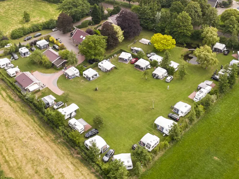 Luftaufnahme des Geländes mit den Stellplätzen rund um die offene Wiese
