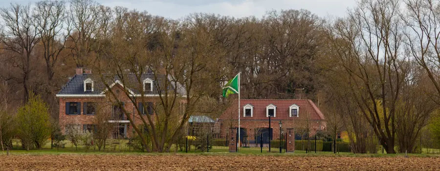 Een Achterhoeks erf achter een akker, met de Achterhoekse vlag aan de mast