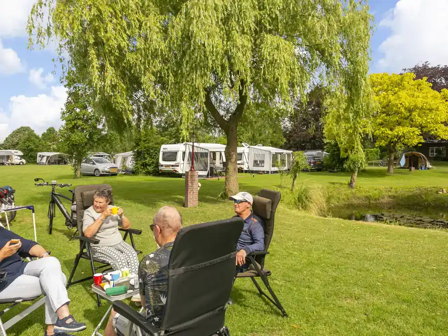Gasten aan een tafel voor hun caravan op het kampeerveld