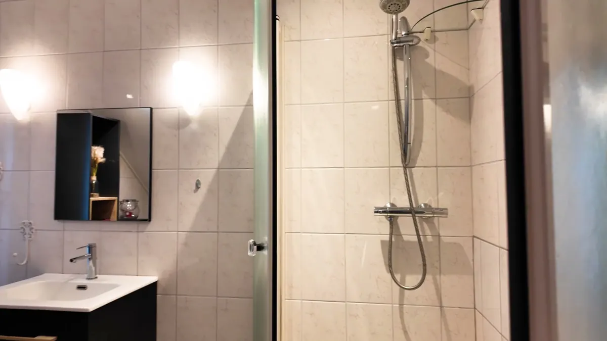 De doucheruimte met inloopdouche en wastafel