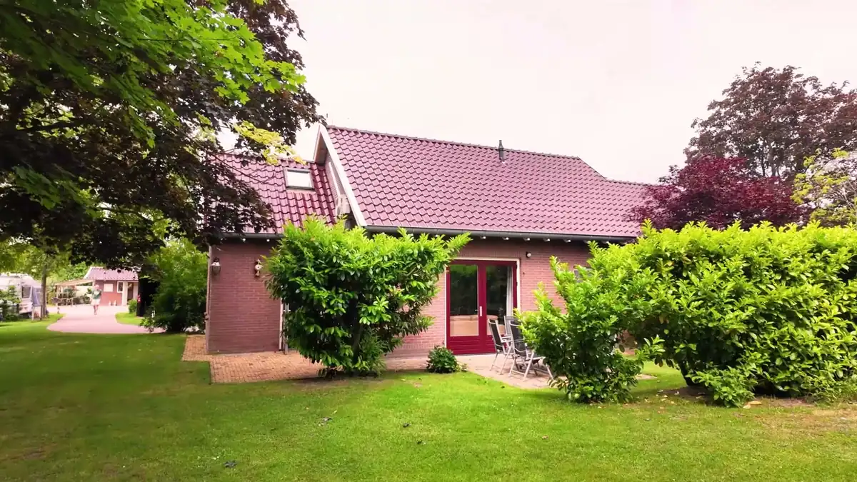 De vakantiewoning met rode dakpannen, gezien vanuit de tuin