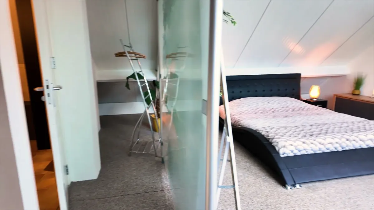 Slaapkamer met kingsize bed onder het schuine dak