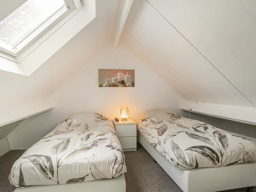 De derde slaapkamer met twee eenpersoonsbedden onder het dakraam