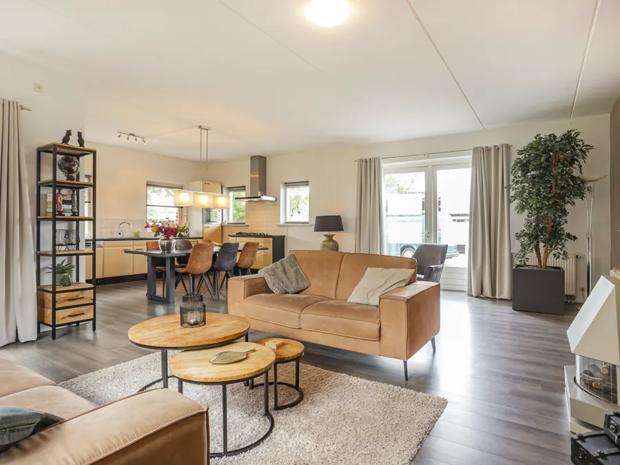 De woonkamer met doorkijk naar de open keuken en de eettafel